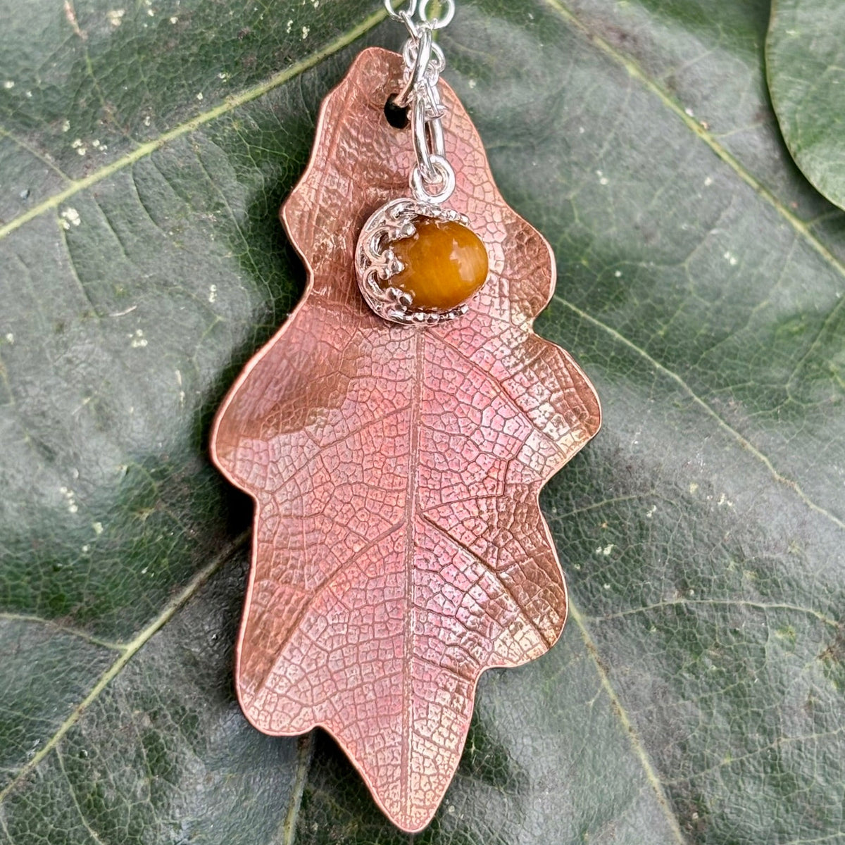 Rowan Berry Jewellery handcrafted copper oak leaf necklaces in three styles: simple leaf, sculptural statement leaf and oak leaf with sterling silver tiger's eye acorn.