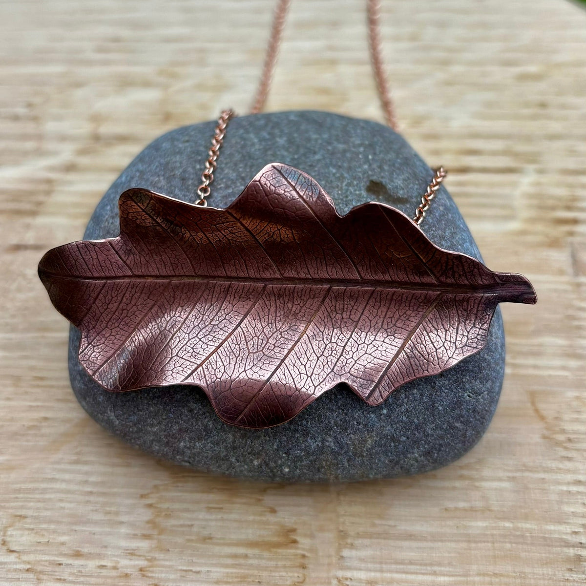 Rowan Berry Jewellery handcrafted copper oak leaf necklaces in three styles: simple leaf, sculptural statement leaf and oak leaf with sterling silver tiger's eye acorn.