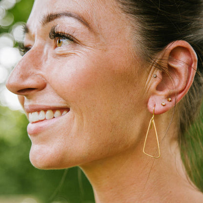 Copper Bee Simplicity Collection polished brass organic triangle earrings with softly curved edges and gold-plated hooks