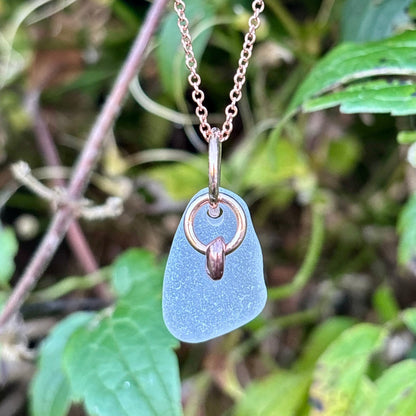 Rowan Berry Jewellery sea glass and hag stone necklace featuring frosted seafoam sea glass, a handcrafted copper hag stone and two bronze hoops on a rose gold-plated chain.