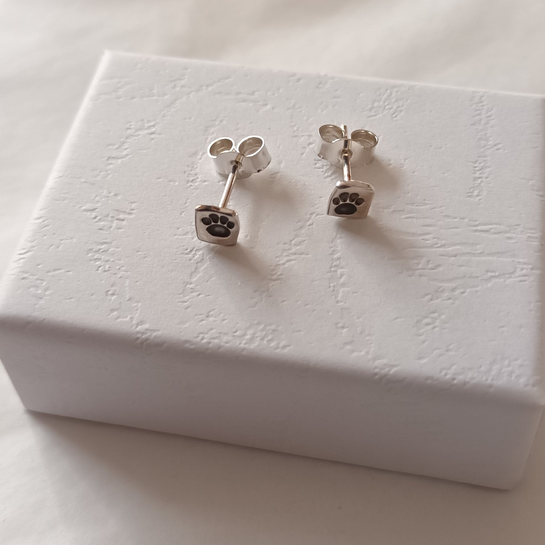 Sterling silver paw print stud earrings by Diana King handmade in Perthshire