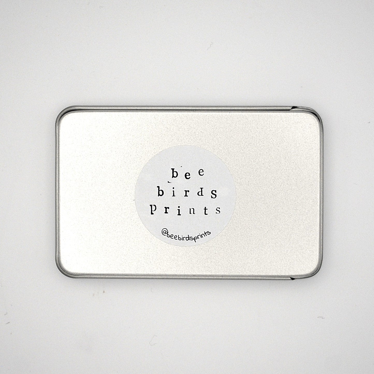 Base of silver rectangular tin with Beebirds sticker