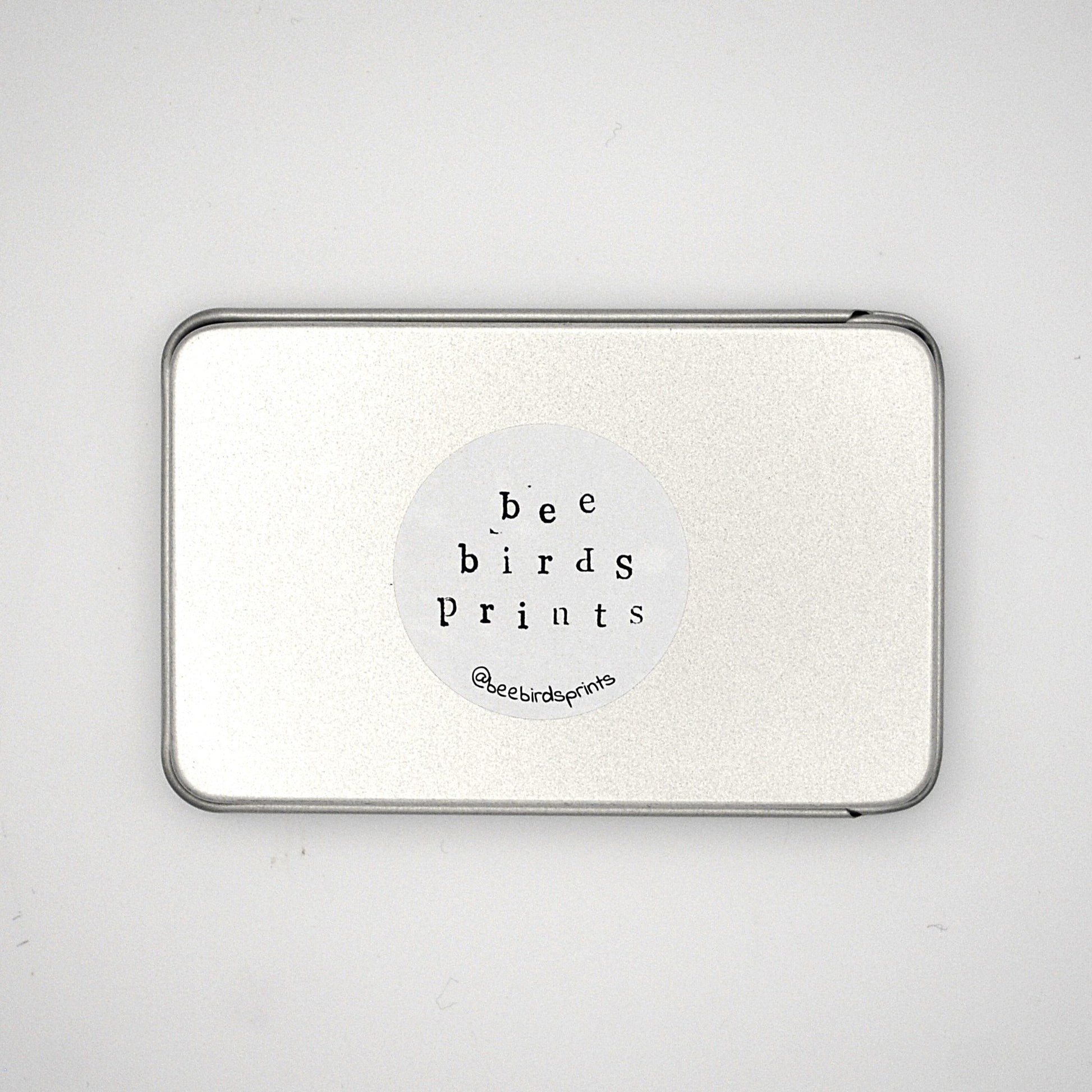 Base of silver rectangular tin with Beebirds sticker
