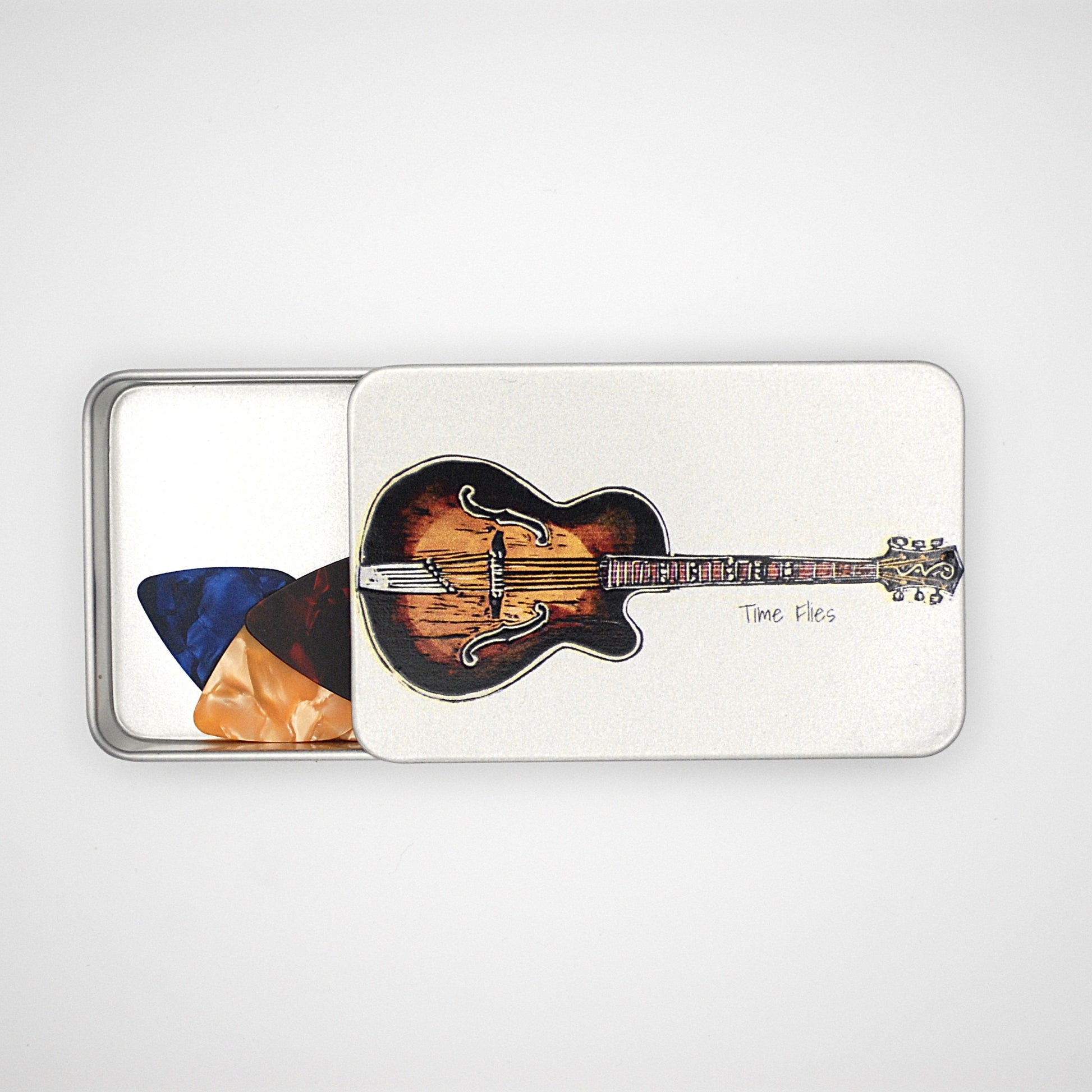 Silver rectangular tin with sliding lid featuring a guitar image with the phrase 'Time Flies' written on it and picks inside