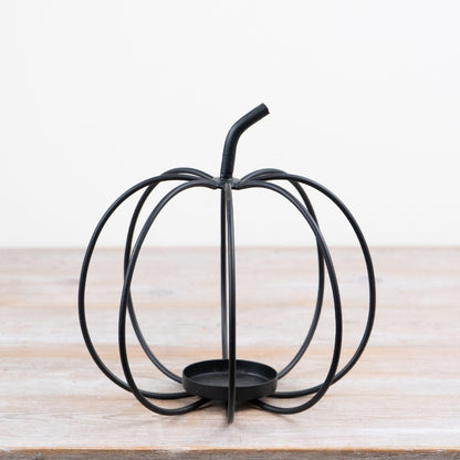 Dark metal open frame pumpkin tealight holder with sculptural curved design for autumn décor