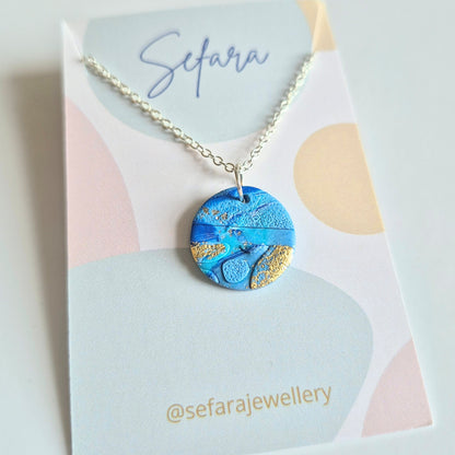 Blues round pendant necklace with a unique design on a Sefara branded card