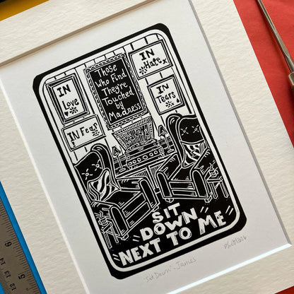 Sit Down by James Black and White Lino Print on a colourful background