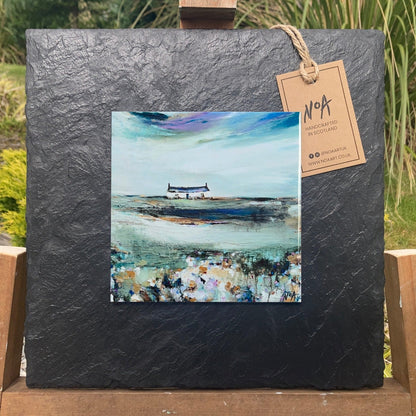 A ceramic tile print of a colourful painting titled 'Spring Days', showing a small house nestled in the Scottish Highlands, available mounted on natural slate or framed.