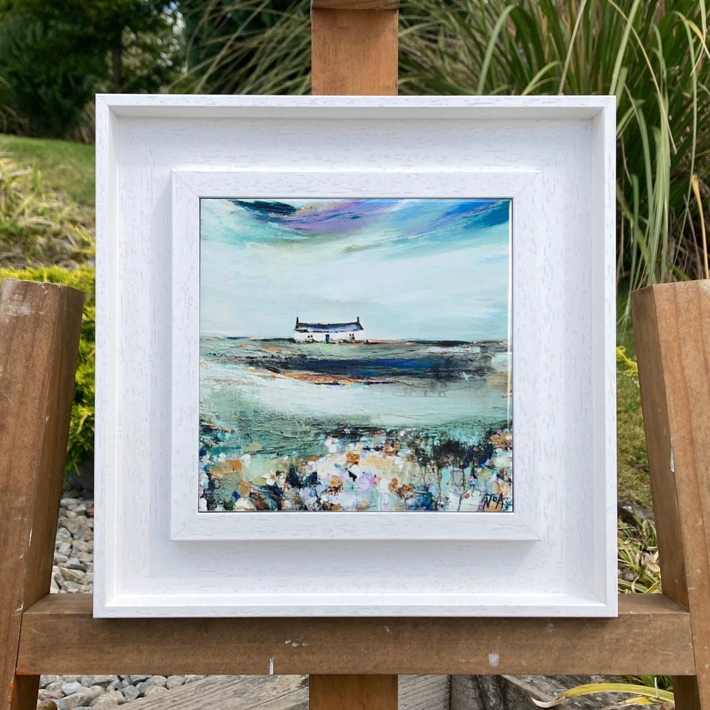 A ceramic tile print of a colourful painting titled 'Spring Days', showing a small house nestled in the Scottish Highlands, available mounted on natural slate or framed.