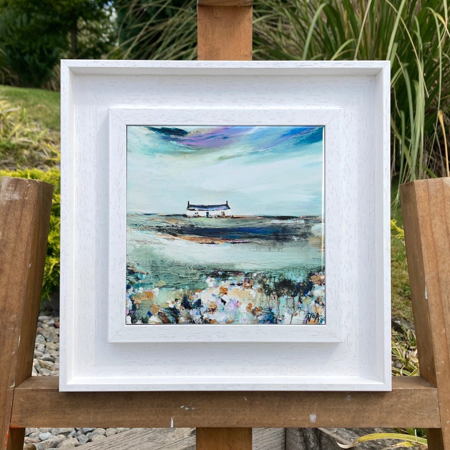A ceramic tile print of a colourful painting titled 'Spring Days', showing a small house nestled in the Scottish Highlands, available mounted on natural slate or framed.
