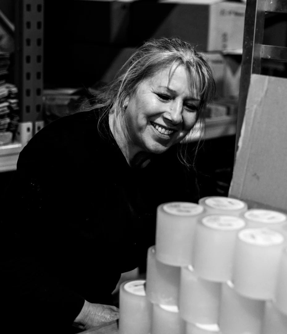 Lady smiling behind a pile of St Eval candles
