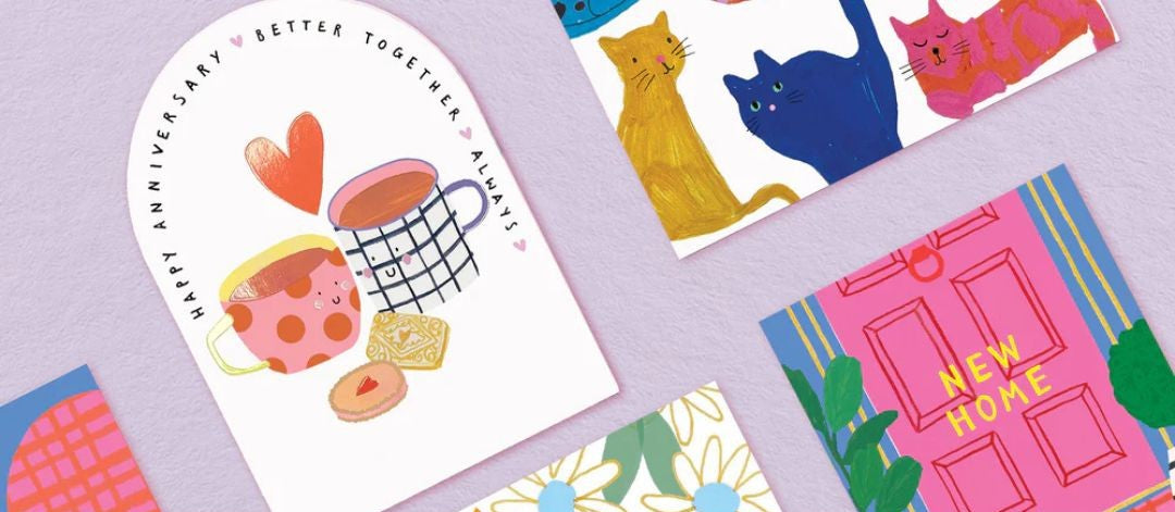 Collection of colourful greeting cards with various designs on a light purple background