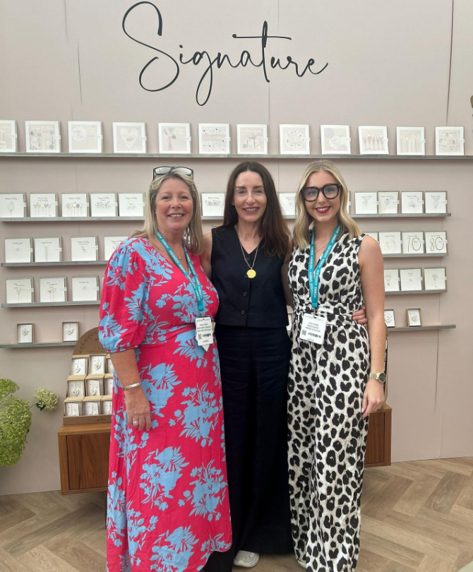 Three female members of Belly Button Designs team at trade show 