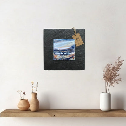 A ceramic tile print of a colourful painting titled 'Telegraph Pole', showing a small house nestled in the Scottish Highlands, available mounted on natural slate or framed.