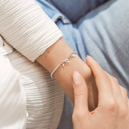 A silver Joma bracelet with a bow charm, packaged in a card that reads 'A Little THANK YOU'.