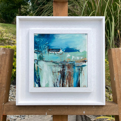 A ceramic tile print of a colourful painting titled 'The Getaway', showing a small house nestled in the Scottish Highlands, available mounted on natural slate or framed.