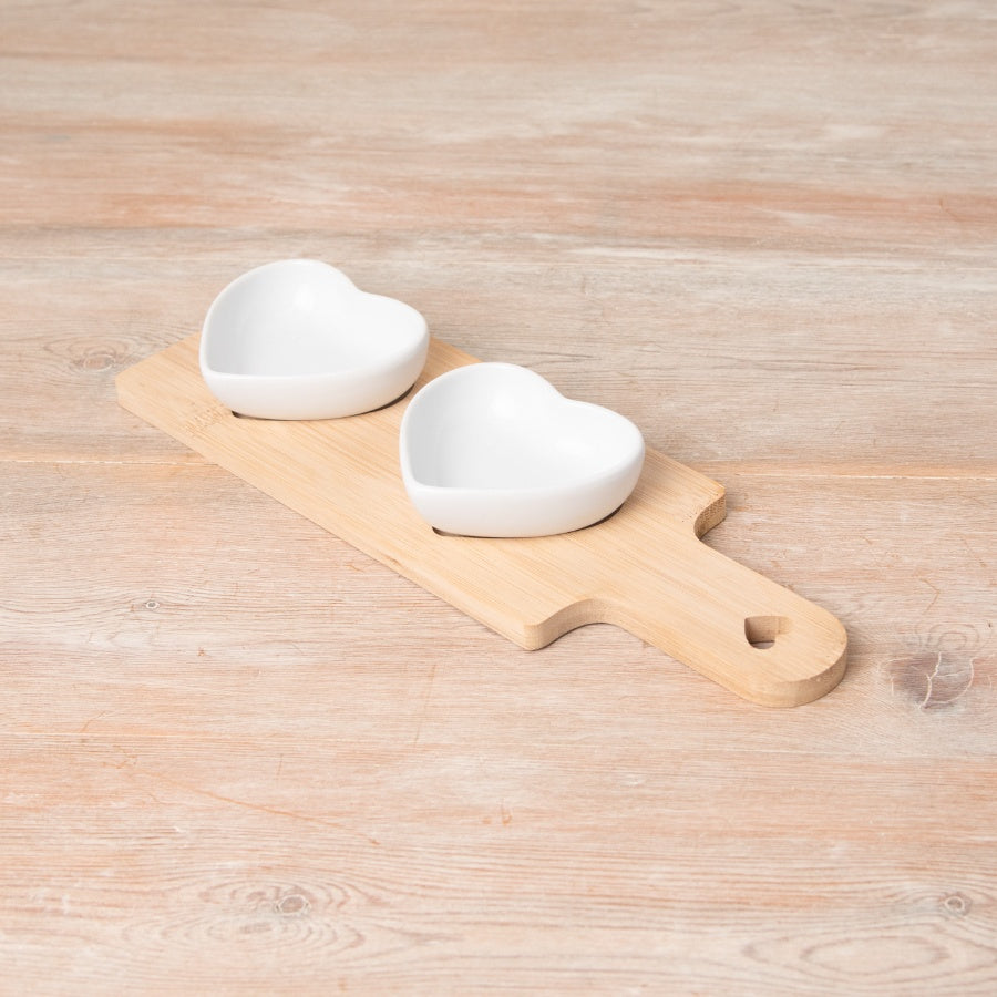 Wooden snack tray with two ceramic heart-shaped dishes for serving snacks and dips
