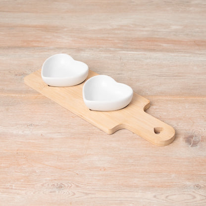 Wooden snack tray with two ceramic heart-shaped dishes for serving snacks and dips