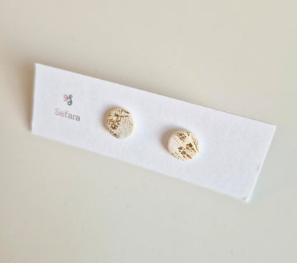 Cream and gold Sefara round stud earrings on a branded card