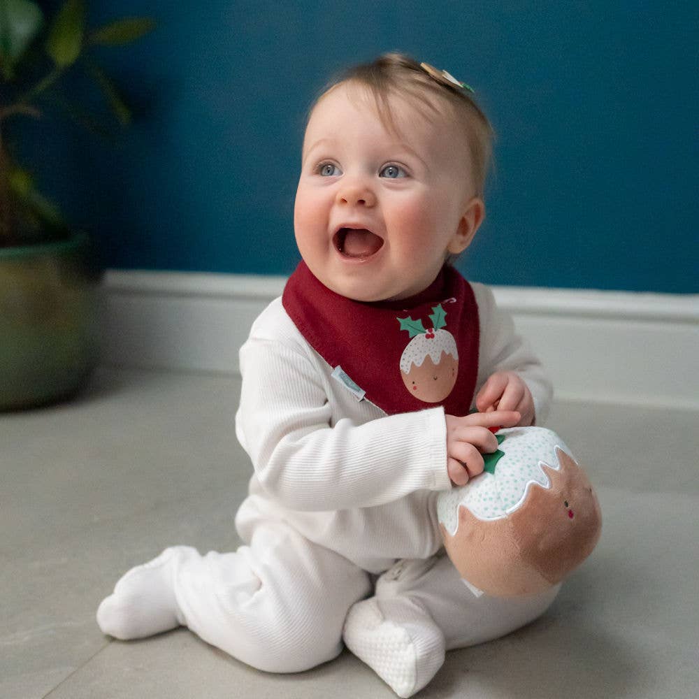 Baby wearing a white onesie and L'il Pudding red Christmas baby bandana bib