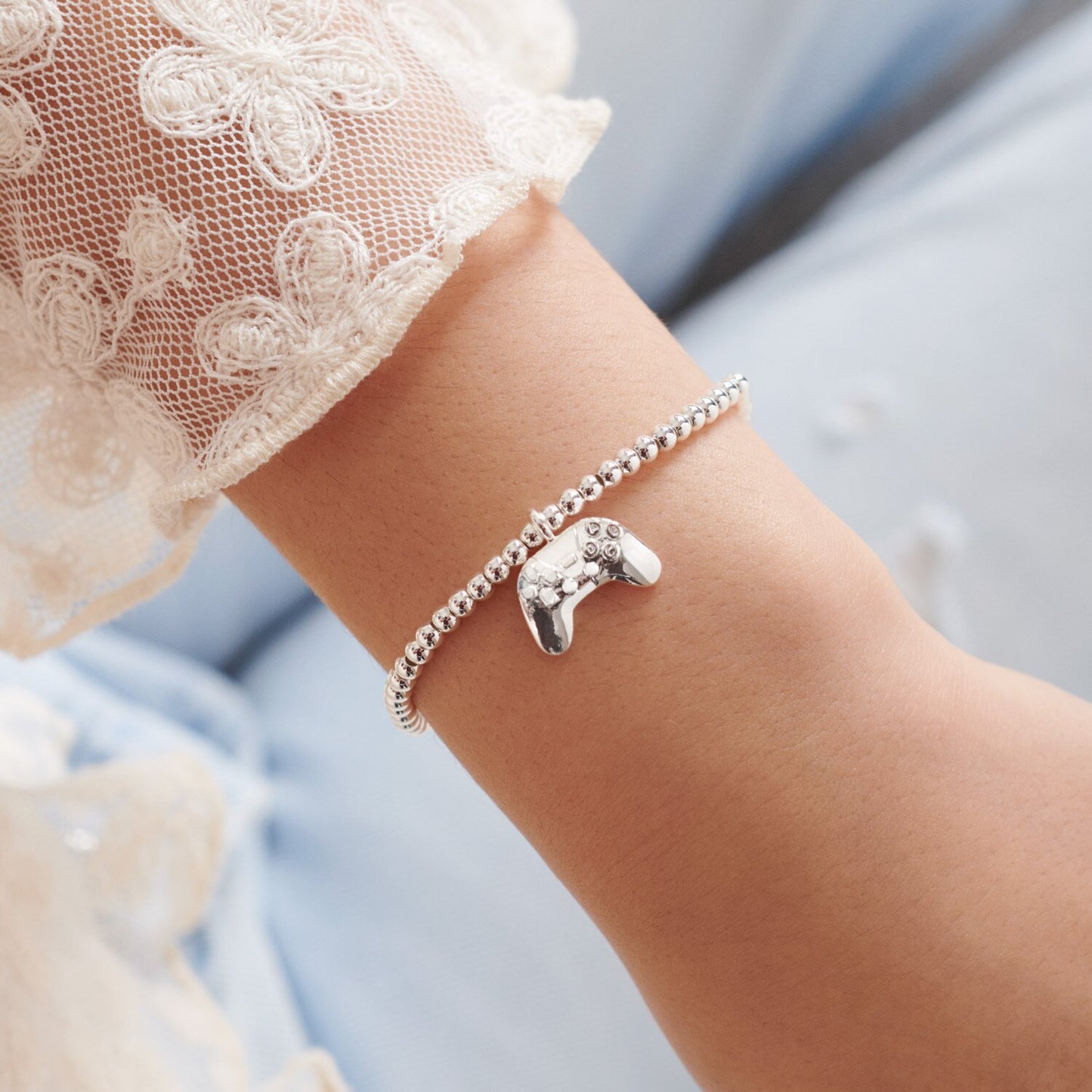'Girl Gamer’ bracelet with gaming controller shaped charm. Silver-plated, stretch fit, and gift boxed