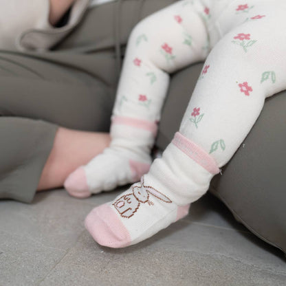 Baby's feet wearing pink cotton baby socks with bunny design, anti-slip soles and ribbed cuffs