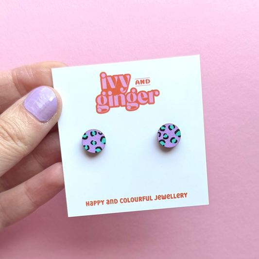 Lilac circle stud earrings with teal and black leopard print, hand painted FSC wood, 10mm, surgical steel posts, bold and colourful design.
