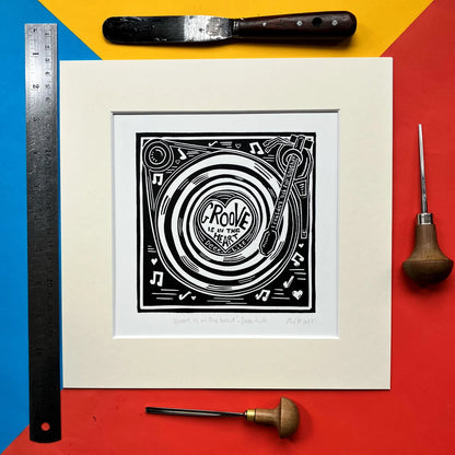 Framed black and white Pamela Scott Groove Is In The Heart lino print artwork with tools on a colourful background